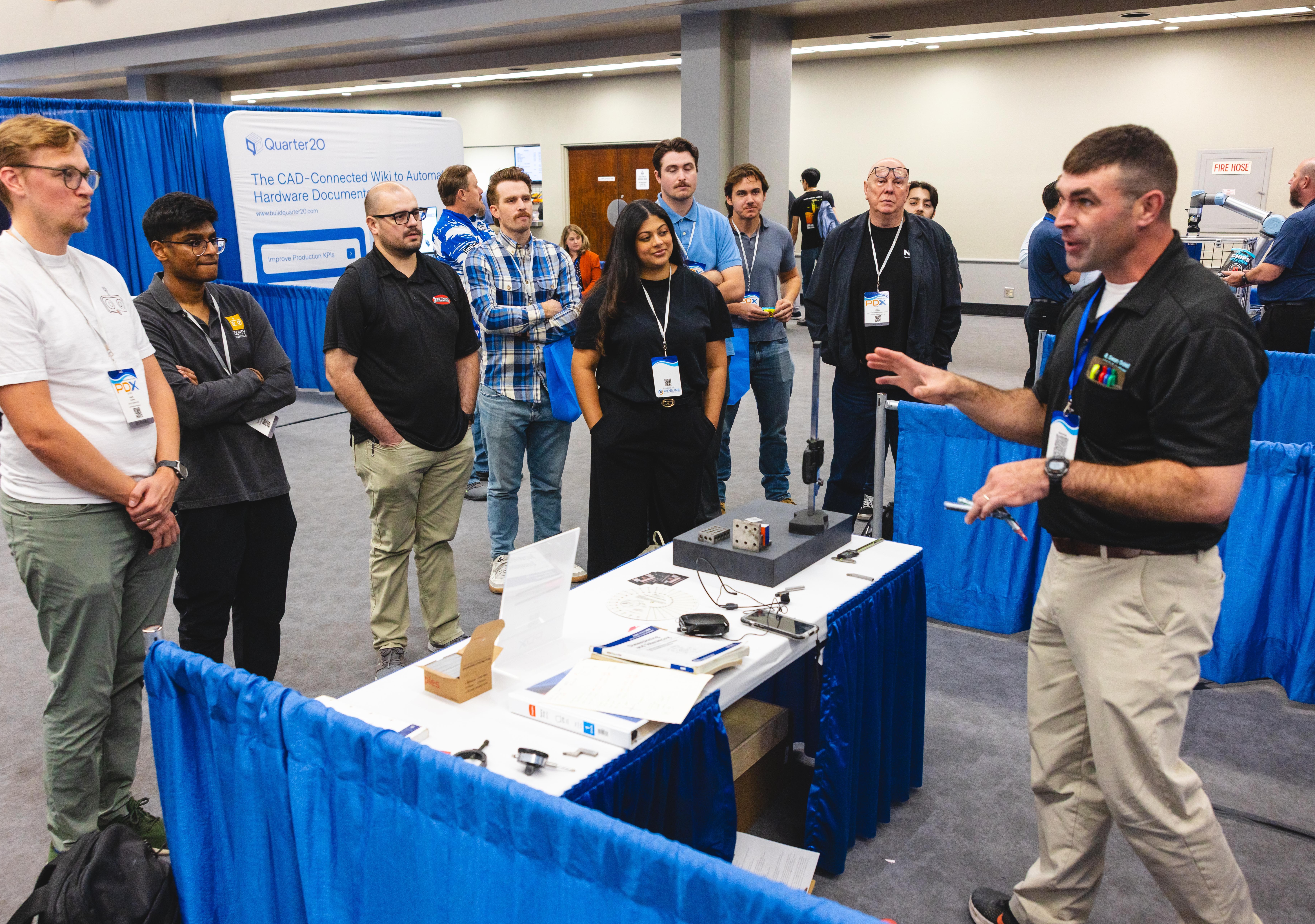 A group of PDX attendees gathered around a technical demonstration